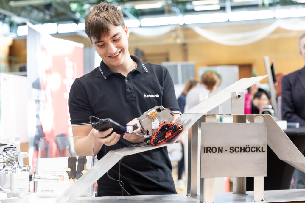 Jugendlicher steuert einen Roboter auf der Bildungsmesse.