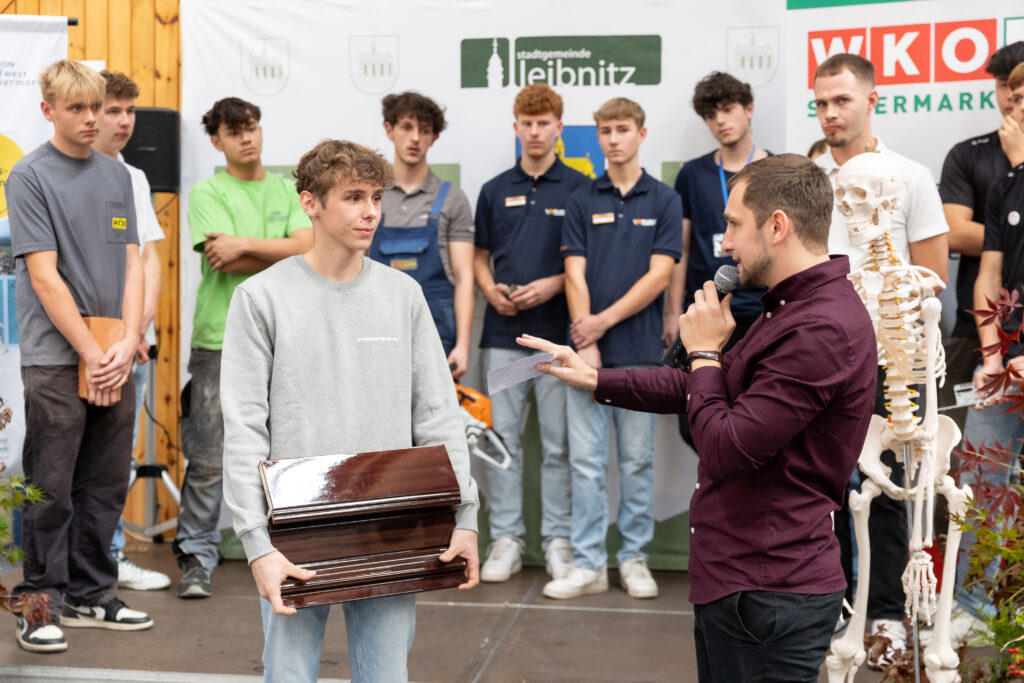 Gruppenbild mit Lehrlingen und Moderator bei einer Präsentation.